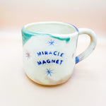 Load image into Gallery viewer, Taza Miracle Magnet -  ojitos cerrados azules
