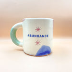 Cargar imagen en el visor de la galería, Taza con Asa - ABUNDANCE - Ojitos del universo
